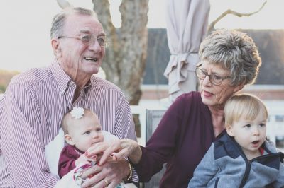 two happy seniors with babies