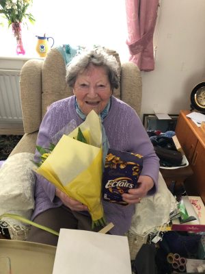 marg smiling with her flowers and chocolate eclairs